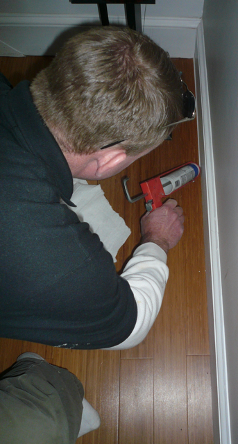 Chris Collar lays down a bead of caulk on the first floor.